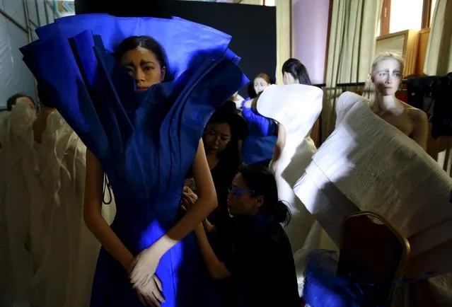 Staff help a model wearing a dress at the backstage before the fashion show of ECHO CHEN Collection at China Fashion Week S/S 2016 in Beijing, October 26, 2015. (Photo by Kim Kyung-Hoon/Reuters)