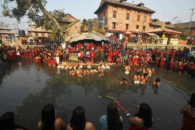 Hindu devotees take part in a bathing ritual on the last day of the month-long Madhav Narayan festival along the river Hanumante in Bhaktapur on the outskirts of Kathmandu on February 5, 2023. (Photo by Prakash Mathema/AFP Photo)