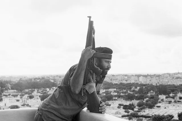 A soldier with Fidel Castro's rebel forces keeps watch from a high building overlooking part of Havana, January 3, 1959 as the city awaited the arrival of the rebel leader and other members of his provisional government. (Photo by AP Photo)