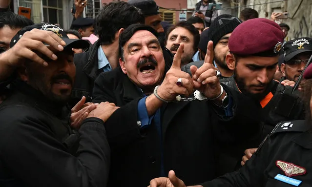 Police officials escort Pakistan's former interior minister Sheikh Rashid Ahmed (C) to present him before a court in Islamabad on February 2, 2023. Pakistan's former interior minister and ally of ousted leader Iman Khan was arrested on February 2, a few hours after another senior opposition figure was released from custody, his party said. (Photo by Aamir Qureshi/AFP Photo)