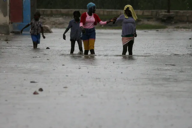 People wade across a flooded street while Hurricane Matthew passes through Port-au-Prince, Haiti, October 4, 2016. (Photo by Carlos Garcia Rawlins/Reuters)