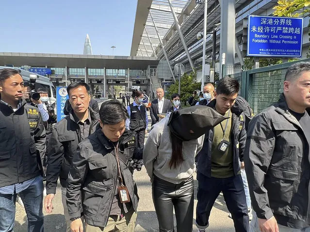 In this photo released by Hong Kong's Information Services Department, Hong Kong police escort a suspect at the Shenzhen Bay Port border crossing in Hong Kong, Tuesday, March 7, 2023. Hong Kong police on Tuesday said a woman accused of assisting another suspect in the gruesome killing of model Abby Choi had been arrested by mainland authorities. (Photo by Information Services Department via AP Photo)