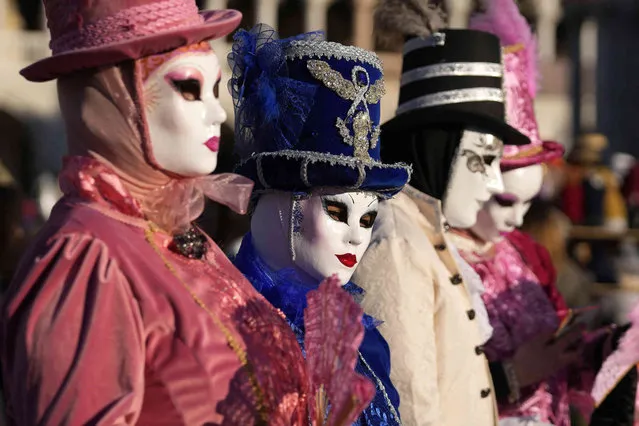 People wear masks in St. Mark's Square, during the Venice Carnival, in Venice, Italy, Sunday, February 13, 2022. Two years after the pandemic shut down celebrations, the Venice carnival in the historical lagoon city is back, attracting people from around the world. (Photo by Antonio Calanni/AP Photo)