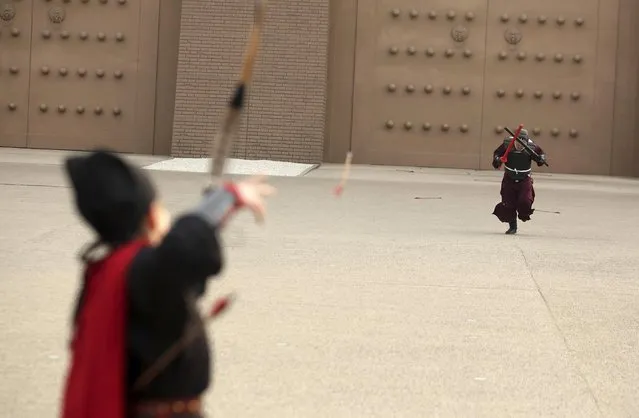 A man (R) dressed in a traditional Han costume and protection gear, runs towards a woman shooting arrows with a bow during a performance called “Da Ba Wang” (or Fight the Overlord) at a tourism resort in Xi'an, Shaanxi province December 20, 2014. The performance, organized by a group of local enthusiasts of costumes from the Han dynasty, aimed to reintroduce winter exercises commonly practised by ancient Chinese soldiers, local media reported. (Photo by Reuters/Stringer)