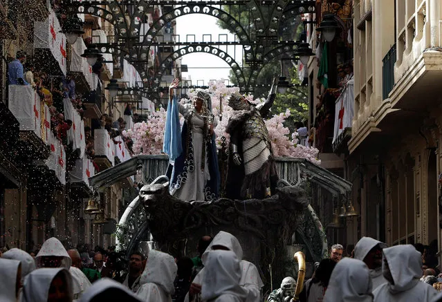 A man (C-R), costumed as the Christian Captain, and a woman in the role of “his favorite lover” (C-L) take part in a parade as part of the traditional “Moors and Christians” Festival in Alcoy, Alicante, eastern Spain, 22 April 2018. The festival, dated back to 1672, attracts some 12,000 people who attend, from 22 to 24 April, the re-enactment of the battle between Christian soldiers of Alcoy against Saracen troops of Moorish leader Al-Azraq on 23 April 1276. According to the tradition, in the most bloody moment of the fight St. George appeared on the site to help the Christian soldiers. (Photo by Morell/EPA/EFE)