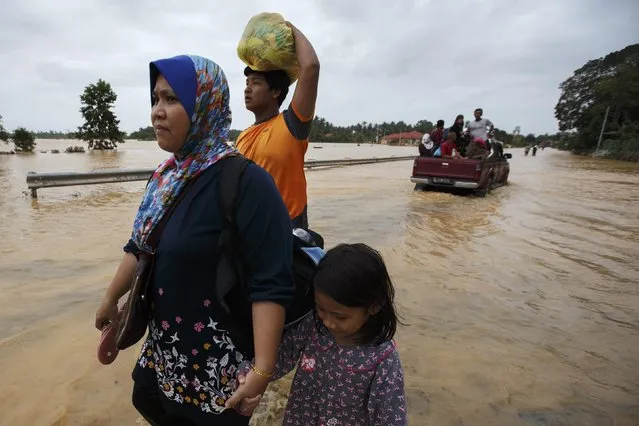 People carry their belongings as they evacuate through a flooded street, on the outskirts of Kota Bharu in Kelantan December 29, 2014. (Photo by Athit Perawongmetha/Reuters)