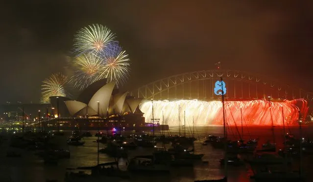 Fireworks light up the Sydney Opera House and Harbour Bridge during an early light show before the midnight New Year fireworks, December 31, 2014. (Photo by Jason Reed/Reuters)