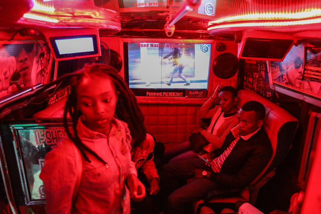 A passenger (L) gets inside a decorated matatu as other passengers wait for it to fill at night in the streets of Nairobi, Kenya, 24 March 2018. (Photo by Daniel Irungu/EPA/EFE)