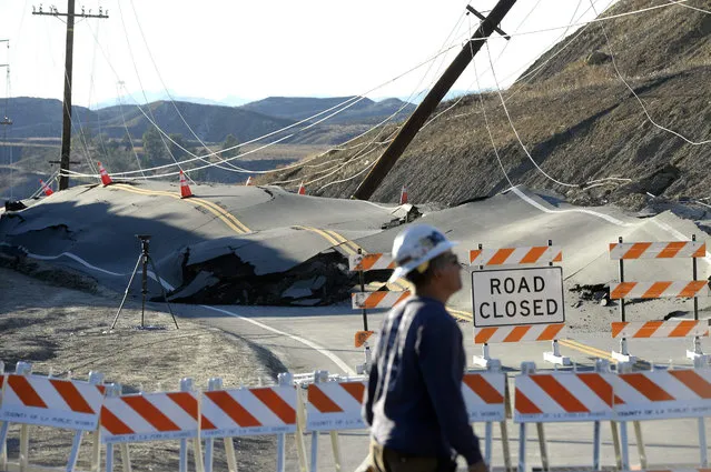 A 'Road Closed' sign is placed next to a portion of Vasquez Canyon Road, near Santa Clarita, California, USA, 20 November 2015, that buckled and was pushed up by a reported landslide. A 2-mile portion of the popular Canyon Country road will remain closed as the road is repaired and electrical and telephone lines are fixed. (Photo by Mike Nelson/EPA)