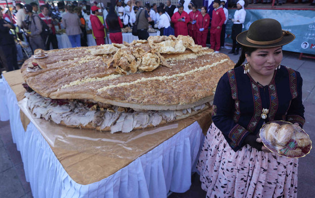 Cholita Eliana Paco poses for a photo during the presentation of a giant “sandwich de chola”, in La Paz, Bolivia, Tuesday, July 2, 2024. Gastronomy experts and student chefs prepared the traditional Bolivian roasted pork sandwich in hopes of breaking the world's record for largest sandwich. (Photo by Juan Karita/AP Photo)