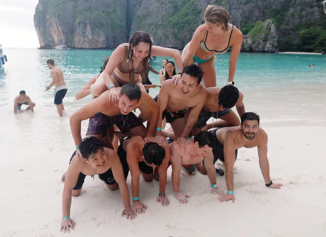 Tourists play as they pose for a group photo at Maya Bay in Krabi province, Thailand May 22, 2018. Across the region, Southeast Asia' s once- pristine beaches are reeling from decades of unchecked tourism as governments scramble to confront trash- filled waters and environmental degradation without puncturing a key economic driver. (Photo by Soe Zeya Tun/Reuters)