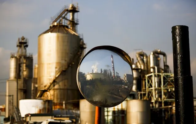 A factory is reflected in a traffic mirror at the Keihin industrial zone in Kawasaki, south of Tokyo, November 30, 2015. Japan's industrial output rose for a second straight month in October and retail sales grew much faster than expected - a tentative sign of the economy's recovery from a recession. (Photo by Thomas Peter/Reuters)