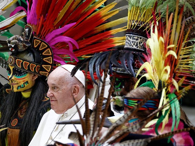 Pope Francis poses with members of “Cultural Diffusion Tonatiuh from Monterrey” for pictures during his weekly general audience in Paul VI hall at the Vatican, on August 7, 2024. (Photo by Guglielmo Mangiapane/Reuters)