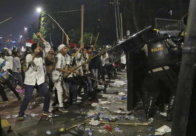 Protesters use sticks to attack riot police during a clash outside the presidential palace in Jakarta, Indonesia, Friday, November 4, 2016. (Photo by Tatan Syuflana/AP Photo)