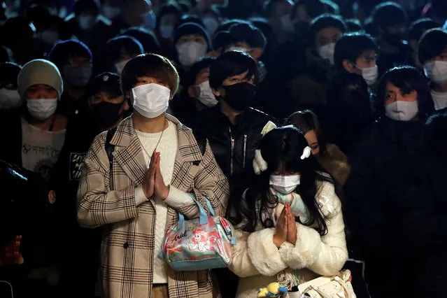 People wearing protective face masks gather as they offer prayers on the first day of the New Year at the Kanda Myojin shrine, amid the coronavirus disease (COVID-19) outbreak in Tokyo, Japan, January 1, 2021. (Photo by Issei Kato/Reuters)
