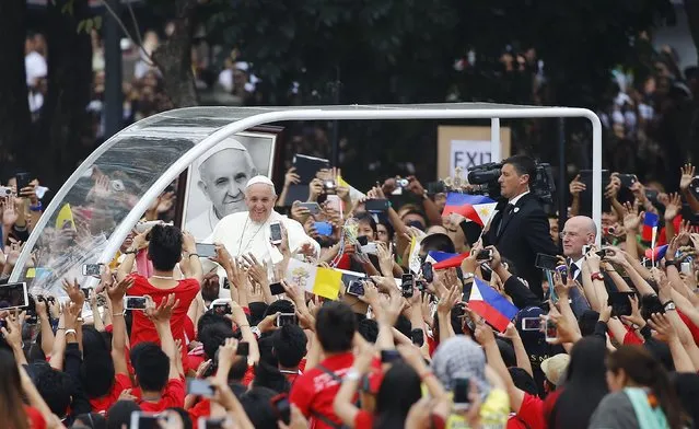 Pope Francis waves as he arrives for a meeting with young people at Manila university, January 18, 2015. The pope held morning meetings with religious leaders and young people at the university before the Mass. (Photo by Stefano Rellandini/Reuters)