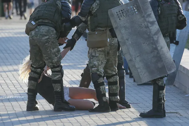 Belarussian policemen detain a woman in central Minsk on August 11, 2020. (Photo by Uladz Hrydzin/Radio Free Europe/Radio Liberty)