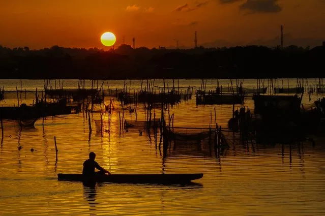 A fisherman fishes in a reservoir at dusk, in Lhokseumawe on May 24, 2023. (Photo by Azwar Iipank/AFP Photo)