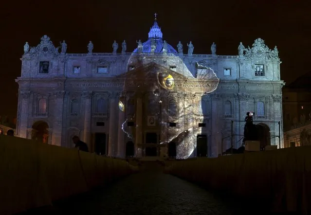 A picture of a stone bass, part of an art projection featuring images of humanity and climate change artistically rendered by Obscura Digital, is projected onto the facade of St. Peter's Basilica, as part of an installation entitled “Fiat Lux: Illuminating our Common Home” as a gift to Pope Francis on the opening day of the Extraordinary Jubilee, at the Vatican, December 8, 2015. (Photo by Stefano Rellandini/Reuters)