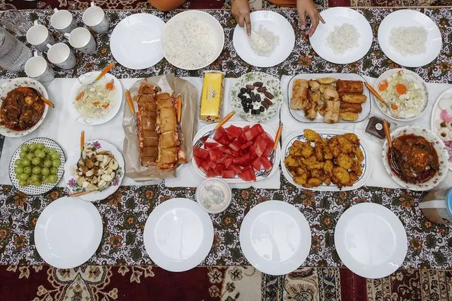 The Ku Abdul Latiff and Norhashimah Ahmad family's meal is set as they wait to break their fast on the first day of Ramadan in Shah Alam, Malaysia, 23 March 2023. Iftar is the fast-breaking meal eaten by Muslims during the fasting month of Ramadan immediately after sunset. Muslims around the world celebrate Ramadan by praying during the night time and abstaining from eating, drinking, and sexual acts during the period between sunrise and sunset. Ramadan is the ninth month in the Islamic calendar and it is believed that the revelation of the first verse in the Koran was during its last 10 nights. (Photo by Fazry Ismail/EPA/EFE)