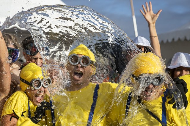 Participants of the 86th edition of the annual Christmas swimming “Coupe de Noel” are sprayed with water before jumping into Lake Geneva, in Geneva, Switzerland, 21 December 2024. More than 4400 men and women swam the 100 meters at the traditional Christmas swimming in Geneva where the water temperature was 7.7 degrees Celsius. (Photo by Martial Trezzini/EPA/EFE)
