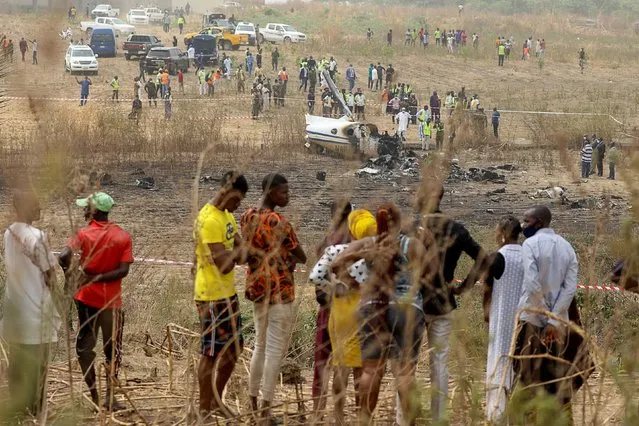 People gather near the site where a Nigerian air force plane crashed while approaching the Abuja airport runway, according to the aviation minister, in Abuja, Nigeria on February 21, 2021. (Photo by Afolabi Sotunde/Reuters)