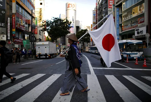 A Japanese soccer fan wearing samurai costume walks on the crossing after the World Cup Round of 16 soccer match Belgium vs Japan, at Shibuya district in Tokyo, Japan July 3, 2018. (Photo by Issei Kato/Reuters)