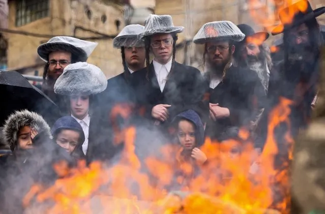 Ultra-Orthodox Jewish men burn leavened items during the Biur Chametz ritual on March 26, 2021 in Jerusalem, before the Jewish Pesach (Passover) holiday. Jewish people throughout the world celebrate the eight days Pesach (Passover) to commemorate the Israelites' exodus from slavery in Egypt some 3,500 years ago and their plight by refraining from eating leavened food. (Photo by Emmanuel Dunand/AFP Photo)