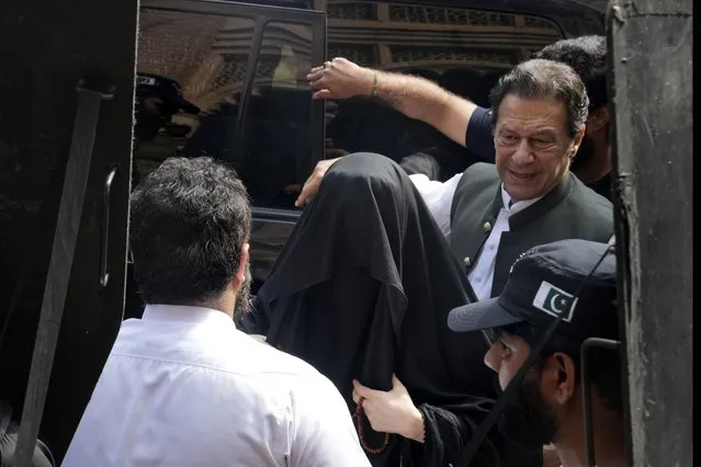 Pakistan's former Prime Minister Imran Khan, right, with his wife Bushra Bibi, center, arrive to appear in a court in Lahore, Pakistan, Monday, June 26, 2023. Khan faces more than 100 legal cases, including on graft charges during his 2018-2022 term as premier, and has also been charged with terrorism for inciting people to violence. In court, he has won protection from arrest in multiple cases, pending trial. (Photo by K.M. Chaudary/AP Photo)