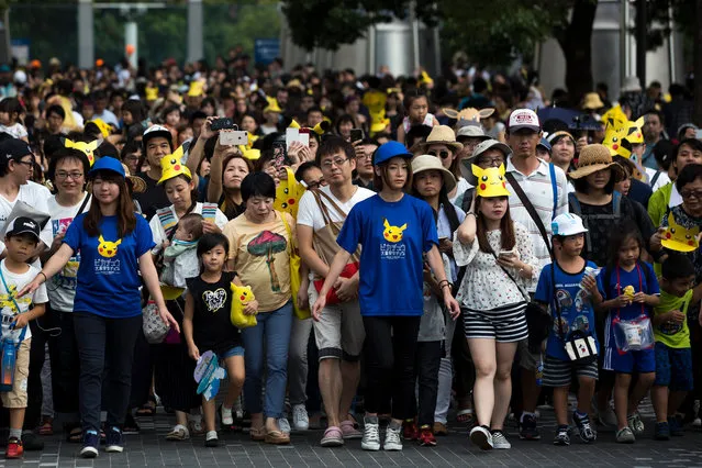People look at performers dressed as Pikachu, a character from Pokemon series game titles, marching during the Pikachu Outbreak event hosted by The Pokemon Co. on August 10, 2018 in Yokohama, Kanagawa, Japan. (Photo by Tomohiro Ohsumi/Getty Images)
