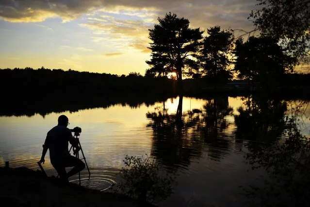 A keen photographer gets his feet wet looking for the perfect angle as the as the sun sets over Hawley Lake near Blackwater, southern England, Britain October 22, 2016. (Photo by Dylan Martinez/Reuters)