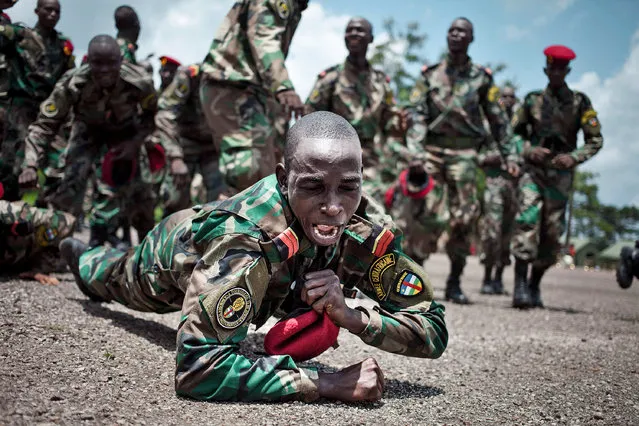 New recruits for the Central African Armed Forces (FACA) celebrate their graduation in Berengo on August 4, 2018. Russian military consultants have set up training for the Central African Armed Forces and the Internal Security Forces after delivering weapons to the country. Already trained by the European program (EUTM), the soldiers are trained in the handling of weapons by the Russian consultants. (Photo by Florent Vergnes/AFP Photo)