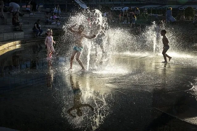 Children cool off in a fountain at VDNKh (The Exhibition of Achievements of National Economy), in Moscow, Russia, Monday, August 7, 2023. (Photo by Alexander Zemlianichenko/AP Photo)
