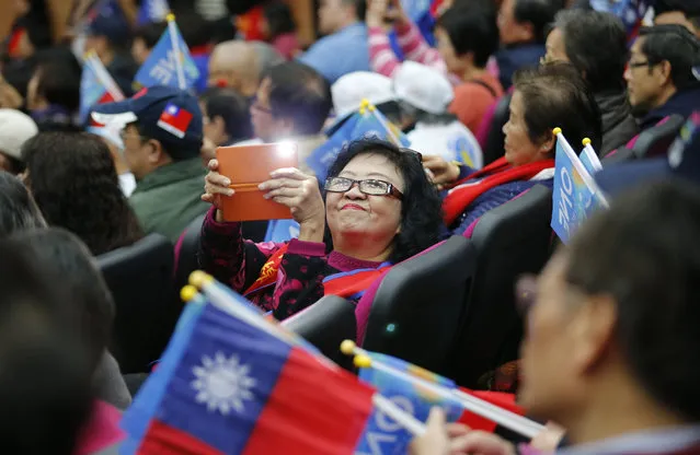 A supporter takes a photo of her friends as Taiwan's ruling KMT or Nationalist Party presidential candidate Eric Chu arrives at a campaign rally in Taipei, Taiwan, Thursday, January 14, 2016. Taiwan will hold its presidential election on Jan. 16, 2016. (Photo by Wally Santana/AP Photo)