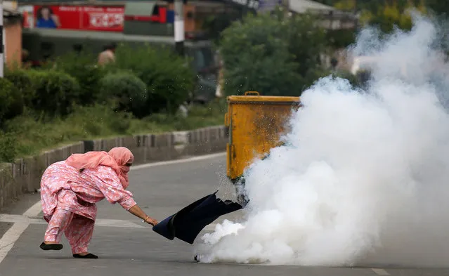 A woman attempts to cover a tear gas canister fired by police at a crowd in Srinagar protesting against the recent killings in Kashmir, August 17, 2016. (Photo by Cathal McNaughton/Reuters)