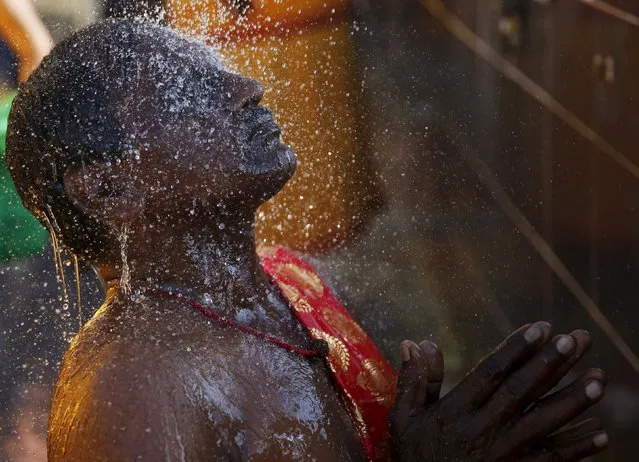 A Hindu devotee prays in the shower before beginning his pilgrimage to Batu Caves during Thaipusam in Kuala Lumpur, Malaysia, January 24, 2016. (Photo by Olivia Harris/Reuters)