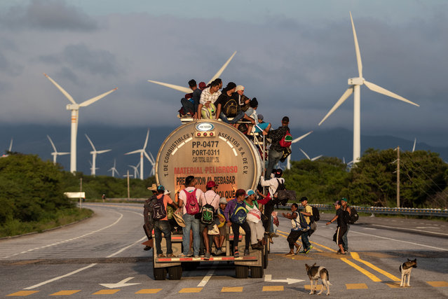 A truck carrying mostly Honduran migrants taking part in a caravan heading to the US, passes by a wind farm on their way from Santiago Niltepec to Juchitan, near the town of La Blanca in Oaxaca State, Mexico, on October 30, 2018. The Pentagon is deploying 5,200 active-duty troops to beef up security along the US-Mexico border, officials announced Monday, in a bid to prevent a caravan of Central American migrants from illegally crossing the frontier. (Photo by Guillermo Arias/AFP Photo)
