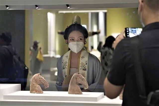 A visitor dressed in Chinese costume poses for a photograph at the Hong Kong Palace Museum during the first day open to public in Hong Kong, Sunday, July 3, 2022. The museum showcases more than 900 Chinese artefacts, loaned from the long-established Palace Museum in Beijing, home to works of art representing thousands of years of Chinese history and culture. (Photo by Kin Cheung/AP Photo)