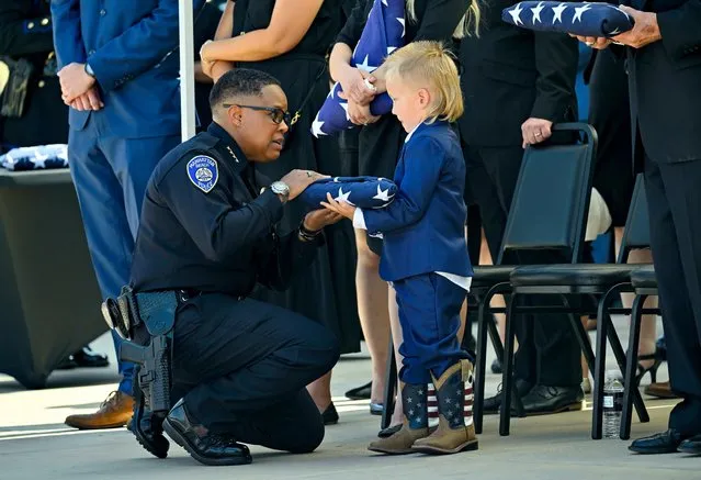 Manhattan Beach Police Chief Rachel Johnson gives a flag to one of motorcycle officer Chad Swanson's sons during his funeral at SeaCoast Grace Church in Cypress, CA, on Wednesday, October 18, 2023. Motorcycle officer Chad Swanson, 35, a 13-year veteran, died in a multi-vehicle crash on the northbound 405 Freeway in the Carson area earlier this month. Swanson was married with three sons. (Photo by Jeff Gritchen/MediaNews Group/Orange County Register via Getty Images)