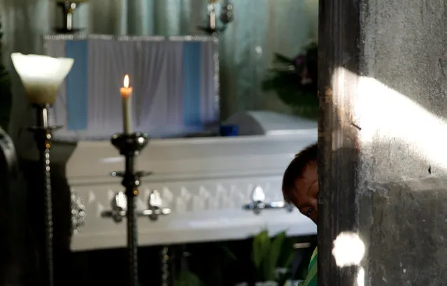 Jay looks outside as he stands near the coffin of his elder brother Jonel Segovia, who was shot dead by suspected vigilantes at a house storing illegal narcotics, police said on Thursday, in Caloocan city, Metro Manila, in the Philippines December 29, 2016. (Photo by Erik De Castro/Reuters)