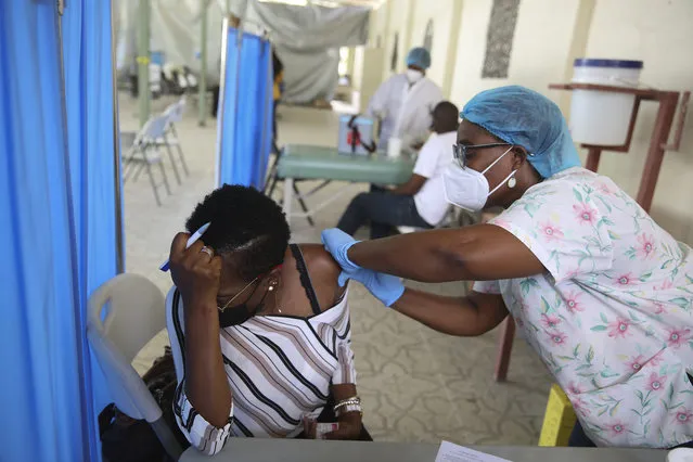 A health worker injects a person with a dose of the Moderna vaccine for COVID-19 at Saint Damien Hospital in Port-au-Prince, Haiti, Tuesday, July 27, 2021. After months of not having any vaccines in the country, the U.S. donated 500,000 doses through the U.N. COVAX system for Haiti in mid-July. (Photo by Joseph Odelyn/AP Photo)