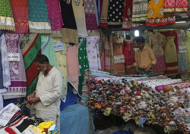 Vendors work as they wait for customers at a garment store in a market in Mumbai, India, February 4, 2016. Doubts about the accuracy of India's gross domestic product figures persist a year after its statisticians unveiled new readings they say better capture value addition down the goods and services supply chain. (Photo by Shailesh Andrade/Reuters)