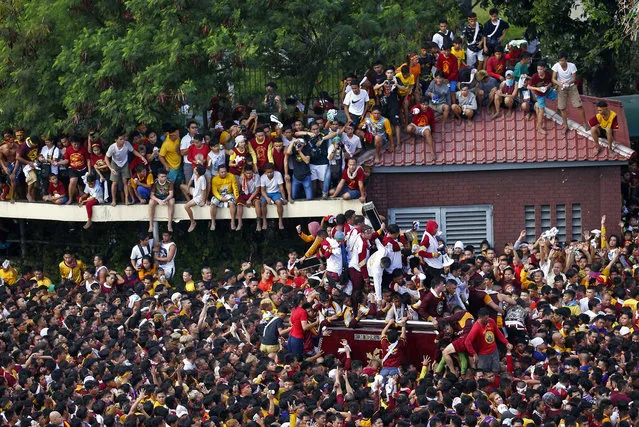 Roman Catholic devotees jostle to kiss and rub with towels the image of the Black Nazarene in a raucous procession to celebrate its feast day Wednesday, January 9, 2019, in Manila, Philippines. Tens of thousands of mostly barefoot Catholics joined the annual procession of a centuries-old statue of Jesus Christ to celebrate the Feast of the Black Nazarene which usually ends before dawn the next day. (Photo by Bullit Marquez/AP Photo)