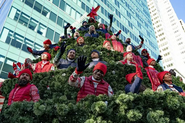 Participants aboard a large Christmas tree float interact with spectators during the 97th Macy's Thanksgiving Day Parade in New York, Thursday, November 23, 2023. (Photo by Peter K. Afriyie/AP Photo)
