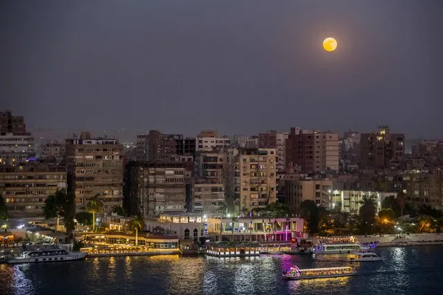 The full Strawberry moon, the last super moon of the year, rises above the Egyptian capital Cairo, on June 24, 2021. (Photo by Khaled Desouki/AFP Photo)