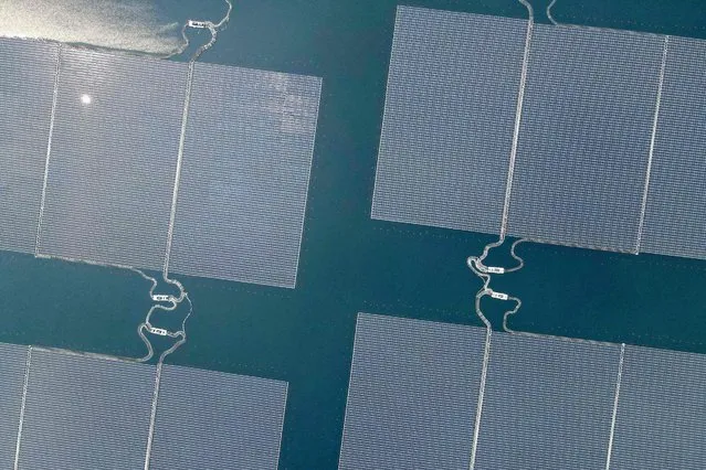 This aerial picture shows the newly built floating solar power plant on the water that can generate 192 mega watts of peak electricity in cooperation between the Indonesian government and Masdar from the UAE, at Cirata Reservoir, West Java, on November 9, 2023, shortly before being inaugurated by President Joko Widodo. (Photo by Bay Ismoyo/AFP Photo)