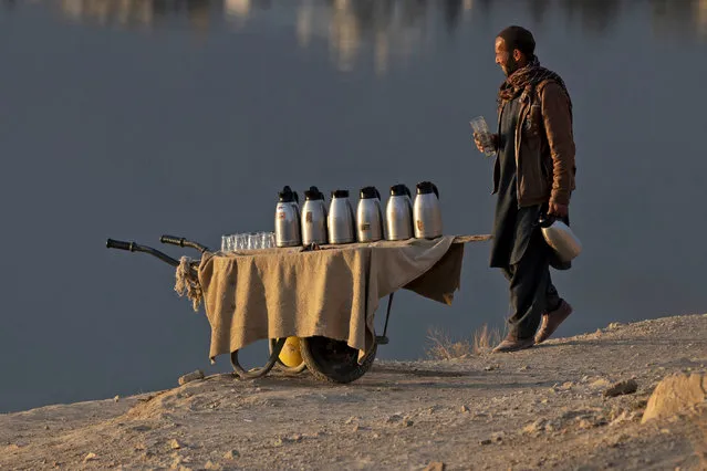An Afghan tea vendor looks for customers along the Qargha lake on the outskirts of Kabul on December 11, 2023. (Photo by Wakil Kohsar/AFP Photo)