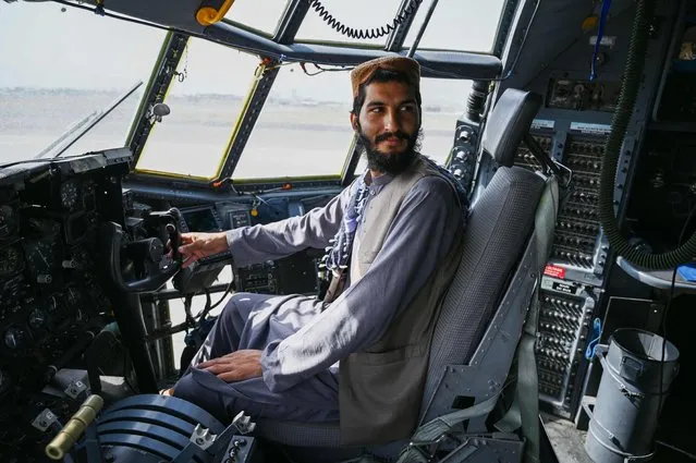 A Taliban fighter sits in the cockpit of an Afghan Air Force aircraft at the airport in Kabul on August 31, 2021. (Photo by Wakil Kohsar/AFP Photo)