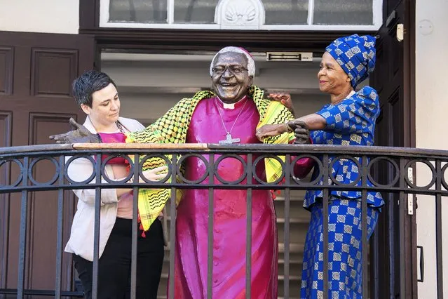 Chairperson of the Archbishop Desmond Tutu Intellectual Property Trust Mamphela Ramphele (R) and Chief Executive of the Desmond & Leah Tutu Legacy Foundation, Janet Jobson (L), put a Palestinian scarf with the African colours produced in Gaza, on a life-size statue of the Archbishop, unveiling the installation which will stand in protest during office hours on the balcony of the Desmond and Leah Tutu Legacy foundation in Cape Town on January 12, 2024. A statue of South African Archbishop Desmond Tutu wearing a Palestinian scarf is to symbolise his decades-long work championing justice for Palestinians, his foundation said. (Photo by Gianluigi Guercia/AFP Photo)
