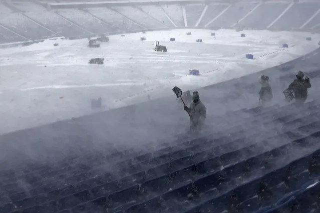 Workers remove snow from Highmark Stadium in Orchard Park, N.Y., Sunday January 14, 2024. A potentially dangerous snowstorm that hit the Buffalo region on Saturday led the NFL to push back the Bills wild-card playoff game against the Pittsburgh Steelers from Sunday to Monday. New York Gov. Kathy Hochul and the NFL cited public safety concerns for the postponement, with up to 2 feet of snow projected to fall on the region over a 24- plus hour period. (Photo by Jeffrey T. Barnes/AP Photo)
